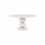 The Misty Country Dining Table features a round white top and a sculptural hand-turned base with three stacked, rounded shapes, showcasing minimalist Italian design.