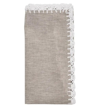 A folded napkin from the Kim Seybert Shell Edge set, featuring beige organic linen with a delicate white lace trim on one side.