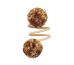 The Kim Seybert Casbah Napkin Ring features a coiled sisal rope with brown and cream bristle pom-poms at each end, offering organic elegance, shown against a white background.
