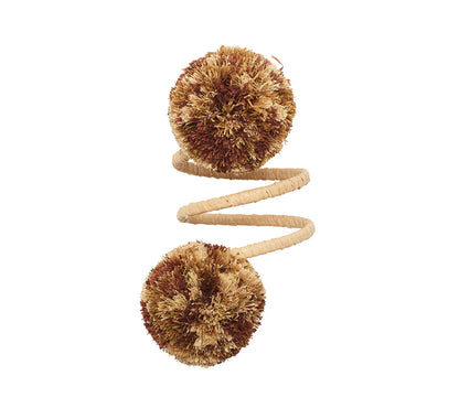 The Kim Seybert Casbah Napkin Ring features a coiled sisal rope with brown and cream bristle pom-poms at each end, offering organic elegance, shown against a white background.