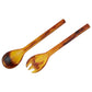 The Tortoise Resin Serveware Collection features a matching spoon and fork, each with marbled yellow and brown resin handles and heads—a stylish addition to your home decor, displayed on a white background.
