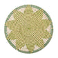 Kim Seybert Majorelle Placemat Collection: round woven wicker placemat crafted from natural seagrass with a green, beige, and white pattern and subtle floral motifs, shown on a white background.