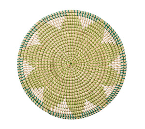 Kim Seybert Majorelle Placemat Collection: round woven wicker placemat crafted from natural seagrass with a green, beige, and white pattern and subtle floral motifs, shown on a white background.
