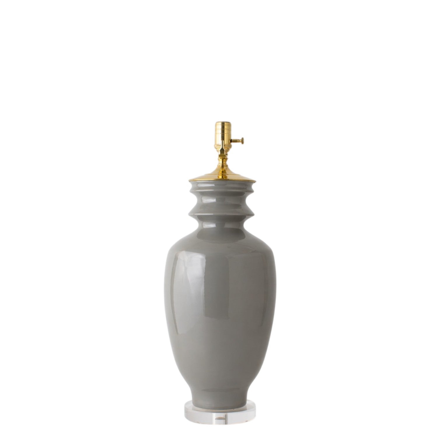 The Marathon Table Lamp in Fossil Grey features a glossy hand-thrown ceramic base, a gold-finished socket, and a clear round acrylic base, displayed against a white background.