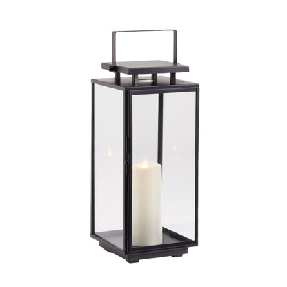 The Napa Alden Outdoor Lantern Small is a black metal and glass lantern with a handle, showcasing a glowing white pillar candle inside—ideal for stylish outdoor lighting.