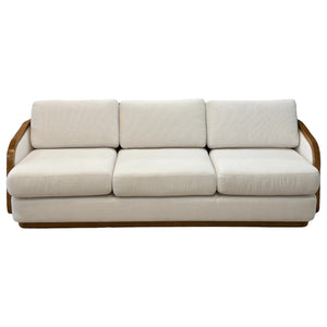 The Schooner Sofa in Outdoor Ivory Chenille features three seats with white cushions and a wooden frame, shown front-facing against a plain background, bringing coastal sophistication and relaxed luxury to your space.