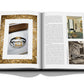 Open book displaying images of a Jaeger-LeCoultre: Reverso wristwatch, an ornate Art Deco room, and wall art, along with text articles on each side.