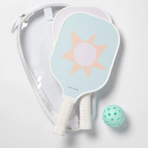 The SUNNYLiFE Pickleball Set in Rio Sun Multi features two sun-patterned paddles with a Polymer Honeycomb core, a light green perforated ball, and a clear carrying case, all shown on a white surface.