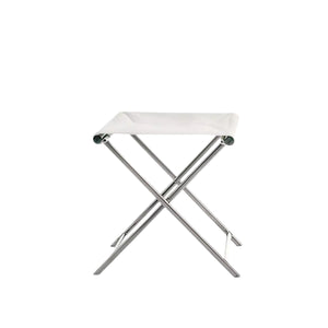The Sundeck Folding Director's Footrest features a metal frame and white fabric seat, inspired by campaign furniture, and is photographed against a plain white background.
