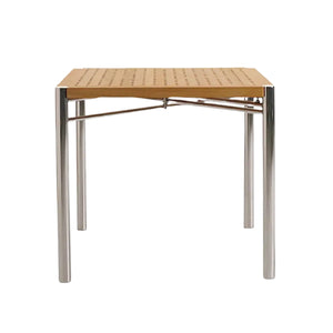 The Sundeck Folding Table is a square teak dining table with a perforated wooden top and four cylindrical marine-grade stainless steel legs, displayed against a plain white background.