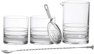 Introducing the Fortessa Crafthouse 5-Piece Mixing Set, featuring a set of clear glass tools including two tumblers, a mixing glass with a spout, a metal strainer, and a stirring spoon with a twisted handle. Designed in collaboration with Charles Joly, it's perfect for any home bar.