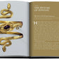 Open book displaying "Jewelry Guide: The Ultimate Compendium" with a golden snake-shaped bracelet adorned with a purple gemstone on one page and text on the other, highlighting the captivating allure of jewels through time.