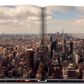 An open New York Chic book with a view of New York City by Assouline.