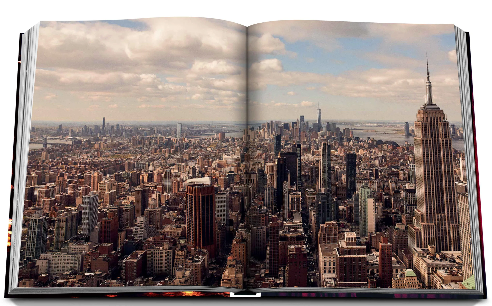 An open New York Chic book with a view of New York City by Assouline.