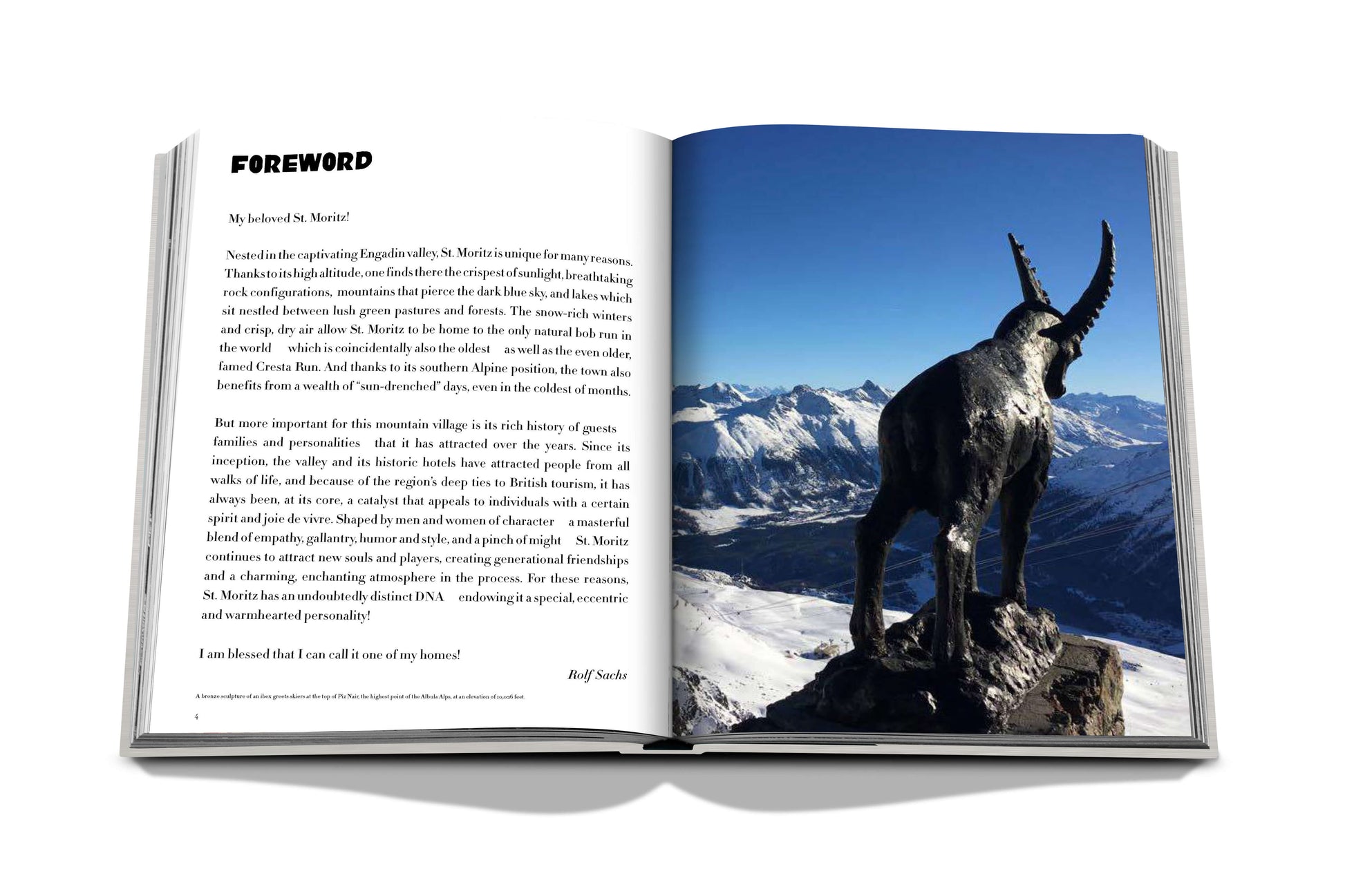 An open book displaying a foreword section on the left page and a photograph of Assouline's St. Moritz Chic with clear blue sky on the right page.