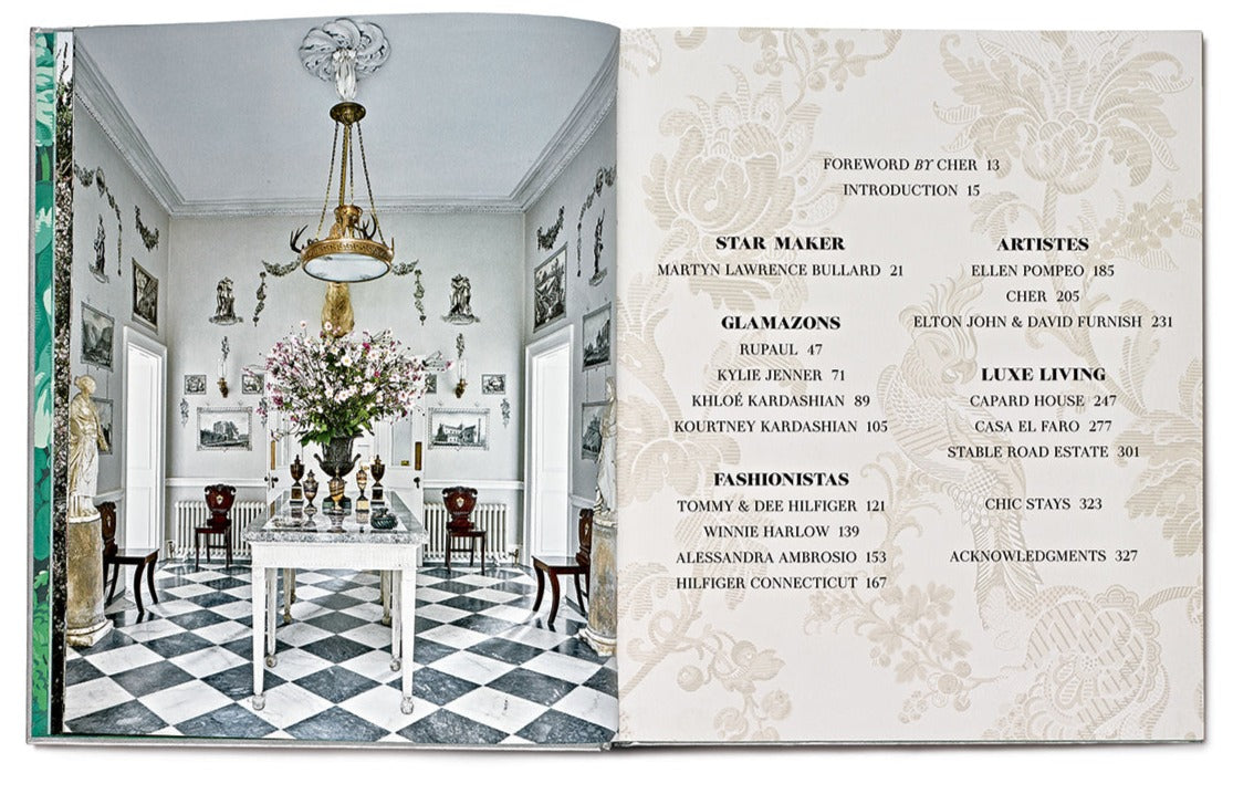 An open book reveals a luxurious dining room reminiscent of celebrity homes, showcasing elegant decor on the left page and a table of contents on the right. The room features a checkered floor, chandelier, and floral arrangement, evoking the eclectic interiors stylized by *Star Style: Interiors of Martyn Lawrence Bullard*.