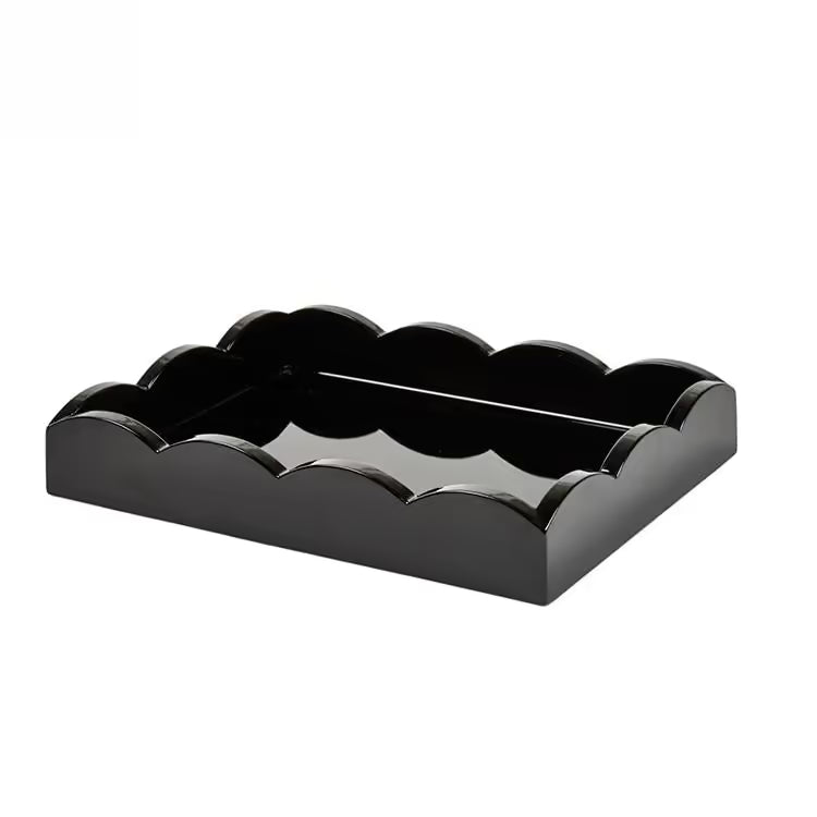 The Scalloped Lacquer Tray in Black features scalloped edges and a glossy finish, making it a stylish drinks tray. Shown on a plain white background.