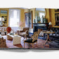 An open book displaying a photograph of a well-decorated living room featuring a fireplace, armchairs, a large mirror, and various art pieces on the walls exhibits The Big Book of Chic's eclectic design approach.