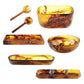 The Tortoise Resin Serveware Collection features amber and brown swirled bowls, trays, a divided dish, and salad servers—stylish resinware perfect for serving or as decor, shown on a white background.