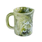A Nashi Home Serveware Collection, Forest measuring cup in green marbled resinware with handle and spout, perfect as unique home decor or a serving piece. Isolated on white background.