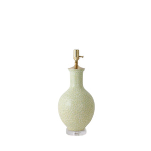 The Presidio Lamp in Dappled Green is a handcrafted ceramic lamp with a pale green, patterned base, brass socket, and clear round acrylic base, shown on a white background.