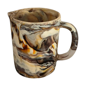 The Arila Jug is a ceramic pitcher with a marbled brown, beige, and cream pattern. It has a handle and spout, making it ideal as a table centerpiece.