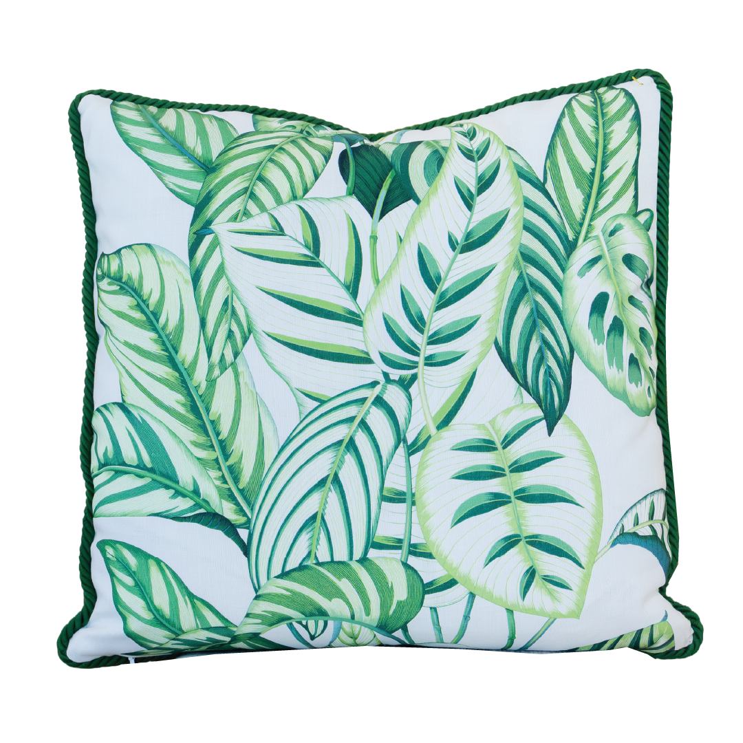 The Calathea Green Outdoor Pillow features a 22x22 square shape with a leafy green tropical pattern on a white background and dark green piping along the edges, making it perfect for adding vibrant style to your patio or garden seating.