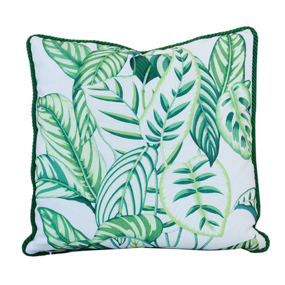 The Calathea Green Outdoor Pillow features a 22x22 square shape with a leafy green tropical pattern on a white background and dark green piping along the edges, making it perfect for adding vibrant style to your patio or garden seating.