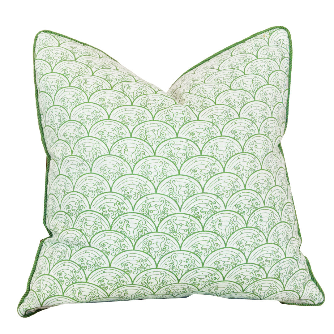 The Wave Grass Pillow, featuring a green and white scalloped pattern with green piped edges, is positioned upright against a plain white background. With a hidden zipper closure for a seamless look, this custom pillow combines style and convenience.