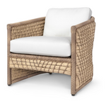 The Capitola Lounge Chair is a square woven rattan chair with a natural-tone frame, white seat and back cushions, and decorative lampakanay rope for added texture.