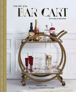 A book titled "Art of the Bar Cart" by Vanessa Dina, featuring styled bar setups with a bar cart stocked with liquor bottles, glassware, and red goblets.