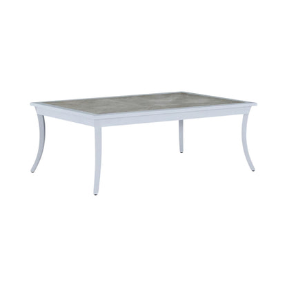 The Bermuda Coffee Table features a light gray rectangular frame, gently curved legs, and a cement-look tabletop with a porcelain inlay—ideal for outdoor use.