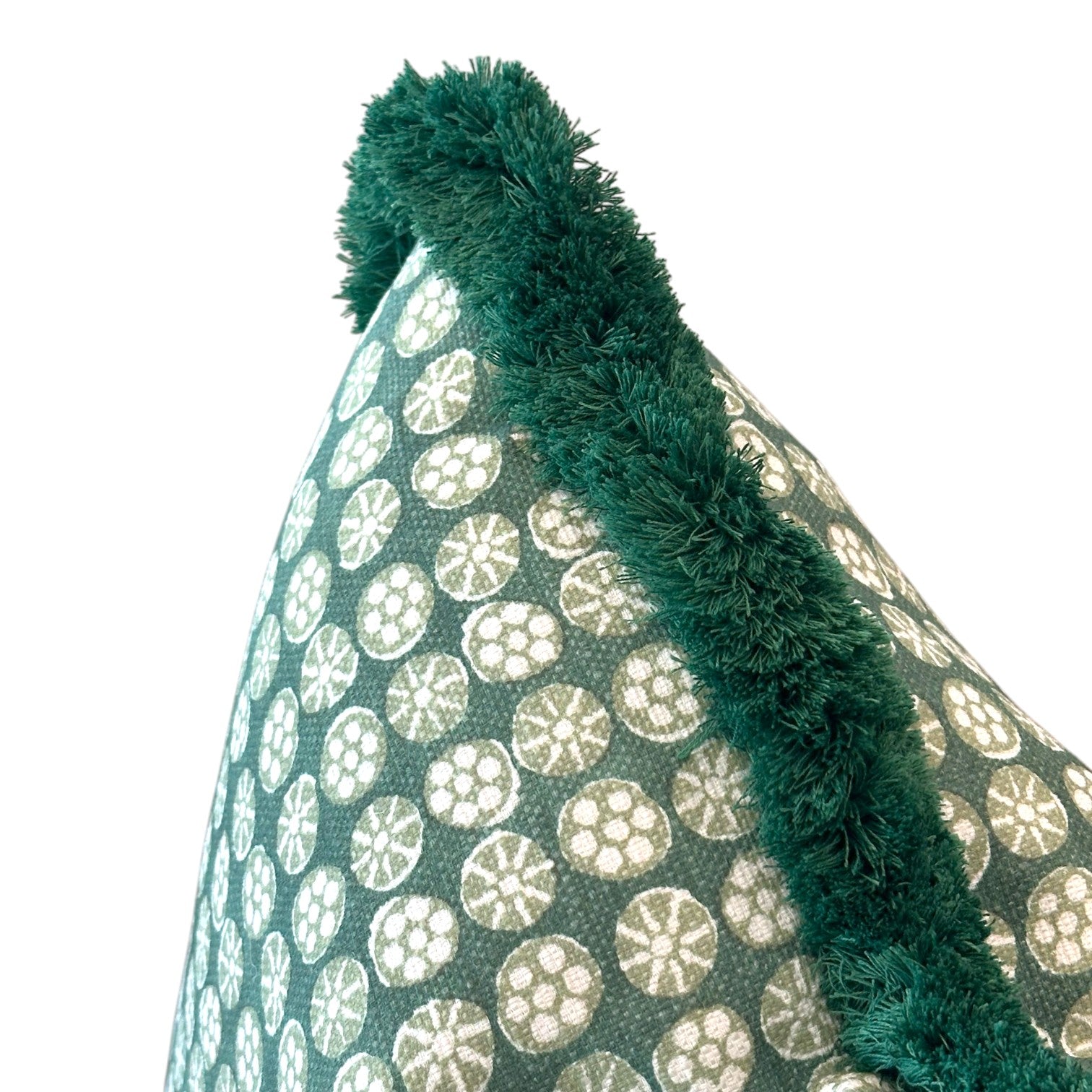 Close-up of the Boheme Green Outdoor Pillow featuring white circular patterns and thick green fringed trim along the edge, expertly crafted for a luxurious touch.