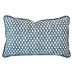 The Burma Indigo Outdoor Lumbar Pillow features a blue and white geometric leaf pattern with blue piping, all set against a white background.