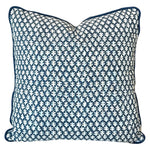 The Burma Indigo Outdoor Pillow is a handmade square pillow featuring a blue and white geometric leaf pattern and blue piping along the edges, crafted from the finest materials.