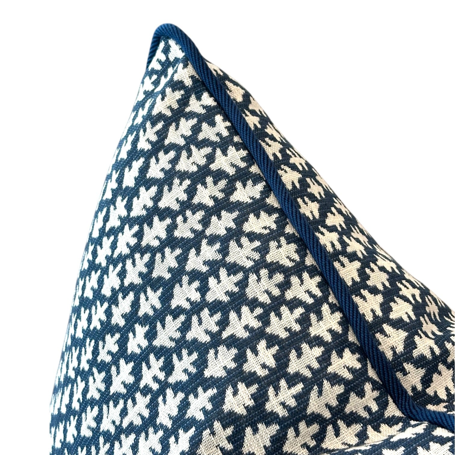A close-up of the Burma Indigo Outdoor Pillow, featuring a navy blue and white pattern, textured fabric, and dark blue piped edge, set against a white background.