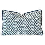 The Burma White Indigo Outdoor Lumbar Pillow features a white background with a dark blue leaf pattern and matching piping—crafted from premium materials for lasting comfort and style.