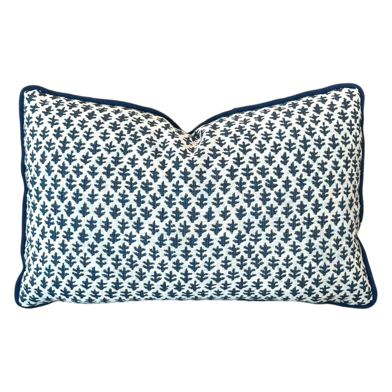 The Burma White Indigo Outdoor Lumbar Pillow features a white background with a dark blue leaf pattern and matching piping—crafted from premium materials for lasting comfort and style.