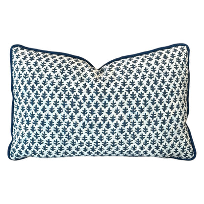 The Burma White Indigo Outdoor Lumbar Pillow features a white background with a dark blue leaf pattern and matching piping—crafted from premium materials for lasting comfort and style.