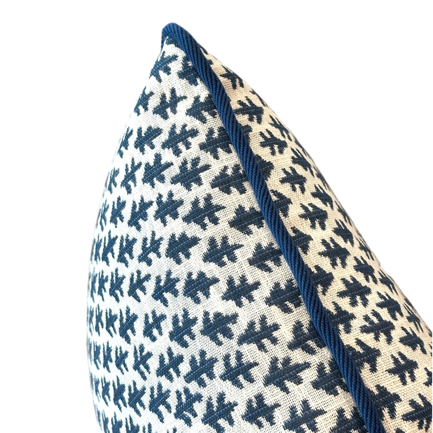 A close-up of the Burma White Indigo Outdoor Lumbar Pillow, showcasing its white cover with a blue leaf pattern and blue piping along the edge, crafted from premium materials and displayed against a white background.