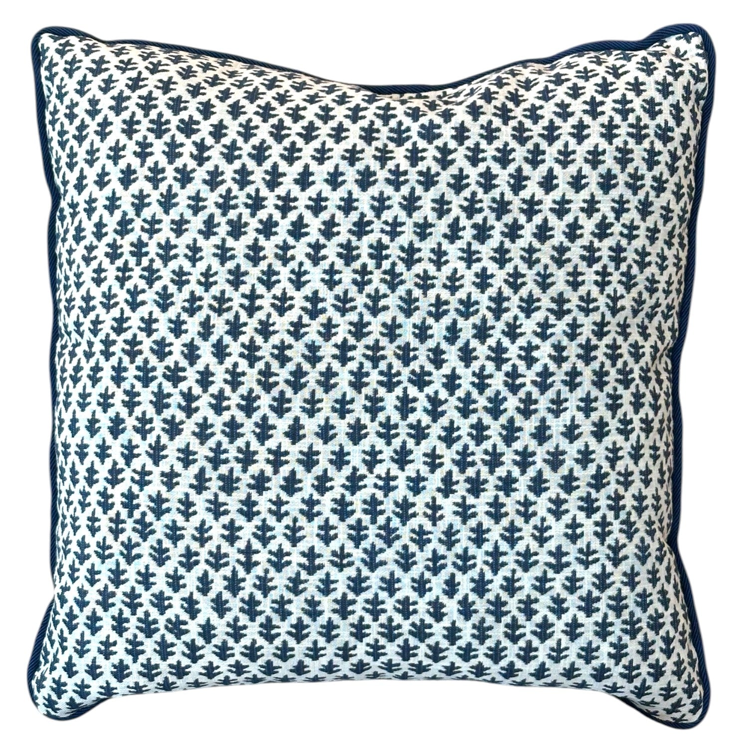 The Burma White Indigo Outdoor Pillow features a white background with a dark blue leaf-like pattern and dark blue edge piping, crafted from premium materials to elevate any space.