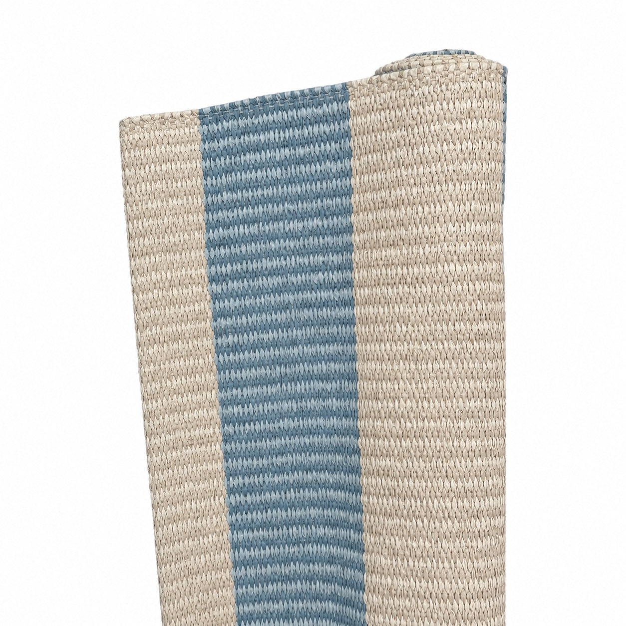A close-up of the Amy Stripe in Medium Blue, a handwoven rug with beige and blue vertical stripes, partially rolled on one end against a white background—designed for versatile indoor or outdoor use.