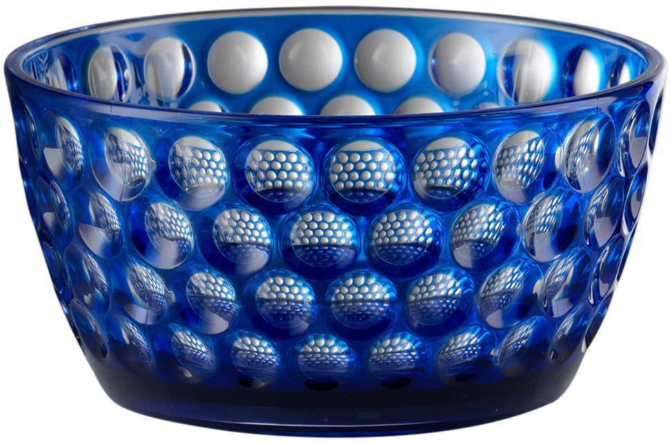 The Mario Luca Giusti Lente Acrylic Collection features a blue bowl with a raised circular pattern that adds a touch of elegance, perfect for outdoor entertaining and designed to brighten any table setting.