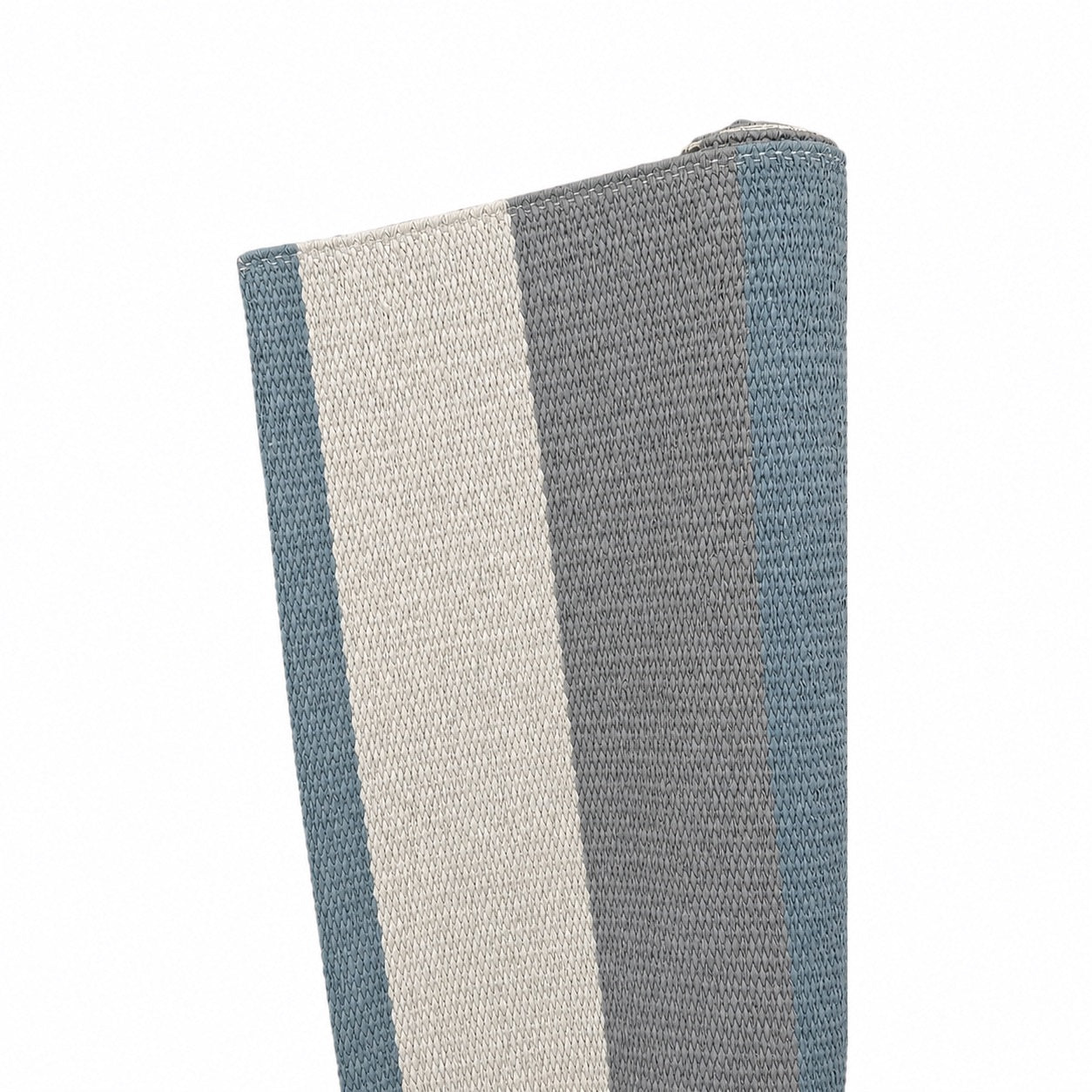 A close-up of the Lina Rug in Chalk, Dark Grey & James Blue shows its hand-woven texture with vertical stripes in blue, gray, and off-white on a white background.