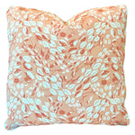 The Cowrie Shell Coral Outdoor Pillow features a peach background with a white and coral leaf design, expertly crafted for lasting comfort.