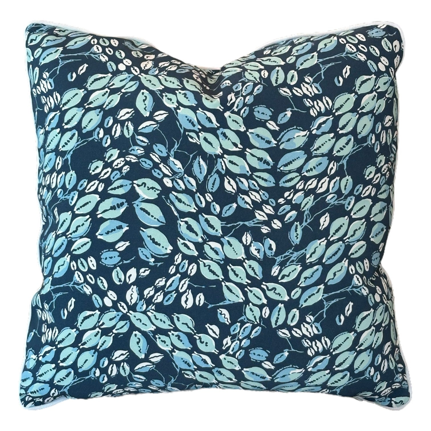 The Cowrie Shell Navy Outdoor Pillow features a dark blue background with a leafy pattern in light blue, green, and white, crafted from premium materials for lasting comfort.