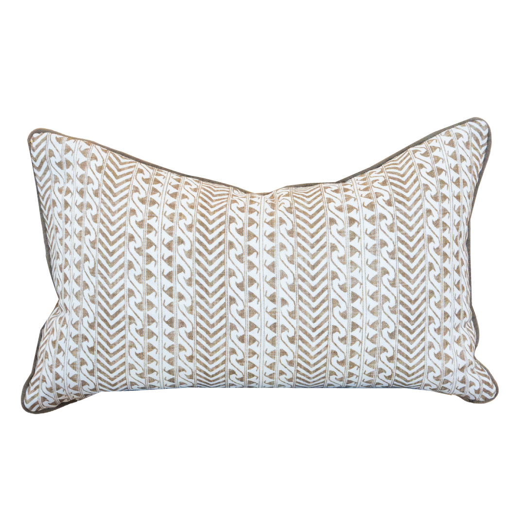 The Luxor Coco Lumbar Pillow is a rectangular cushion showcasing a beige and white geometric chevron and wave pattern, accented with dark piping along the edges. Expertly crafted as one of our custom-made pillows, it features a hidden zipper closure for a seamless finish.