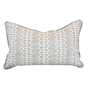 The Luxor Coco Lumbar Pillow is a rectangular cushion showcasing a beige and white geometric chevron and wave pattern, accented with dark piping along the edges. Expertly crafted as one of our custom-made pillows, it features a hidden zipper closure for a seamless finish.