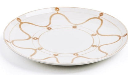 A round, white ceramic plate with a simple brown wavy line and dot pattern around the edge, showcasing the elegance of Themis Z Serenity Beige Collection.