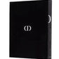 A black book with a minimalist design, featuring the abbreviation "CD" in white on the cover and the title "Dior" on the spine, pays subtle homage to Dior: Gianfranco Ferre's era of haute couture.